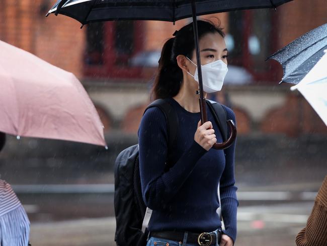 A woman wears a face mask as she walks through Sydney’s Chinatown district. Picture: Getty