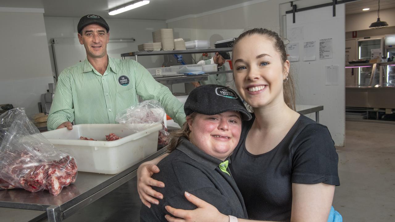 Gabe Hoopert (left) enjoys her job at The Paddock helped by her support worker Jemma Melia. The Paddock owner Ted Ellison in background. Tuesday, October 26, 2021. Picture: Nev Madsen.