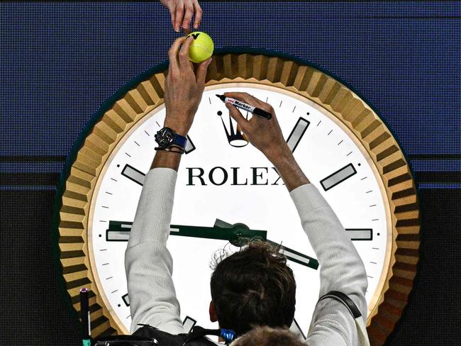 Russia's Daniil Medvedev signs autographs above the clock as he leaves the court after victory against Finland's Emil Ruusuvuori in their men's singles match on day five of the Australian Open tennis tournament in Melbourne early on January 19, 2024. (Photo by Anthony WALLACE / AFP) / -- IMAGE RESTRICTED TO EDITORIAL USE - STRICTLY NO COMMERCIAL USE --