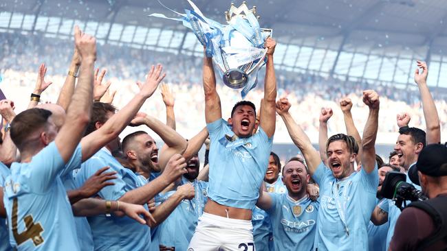 Matheus Nunes of Manchester City celebrates with the Premier League Trophy. Photo by Naomi Baker/Getty Images)