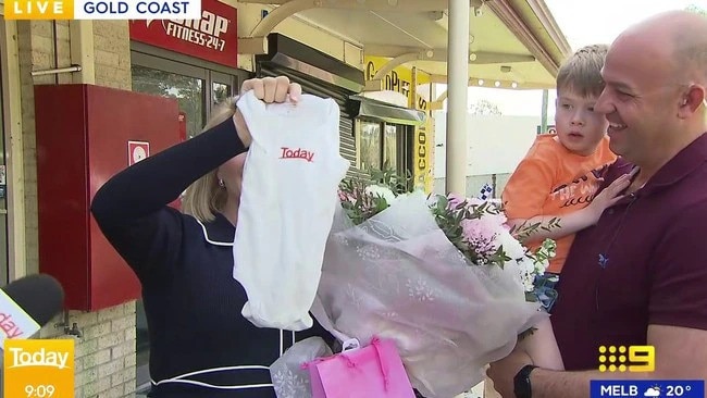 Mia Glover alongside husband Paul and son Albert, holding up a 'Today Show' onesie while reporting from a Gold Coast crime scene. Photo: Instagram/@thetodayshow.