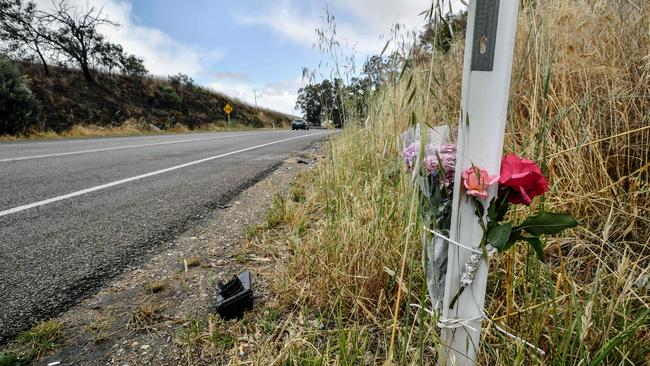 Flowers are seen near the remnants of a car on the road where two teenagers died on Long Valley Road. Picture: AAP Image/ Morgan Sette