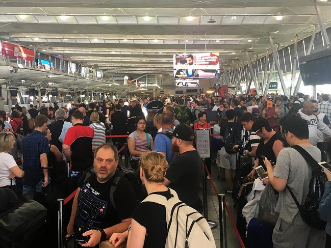 Airline passengers are seen at Sydney Domestic Terminal 2 during a technical delay, Monday, 25 September 2017. Virgin Australia, Qantas and Jetstar have confirmed the problem is affecting flights. Hundreds of passengers have been affected after the "technical issue" occurred about 5am on Monday. (AAP Image/Sallie Don) NO ARCHIVING