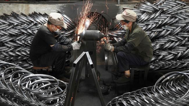 Workers polish bicycle wheels in Hangzhou. China posted on Monday lower than expected growth in the second quarter, with all eyes on how top officials gathering in Beijing might seek to tackle the country's deepening economic malaise. Picture: AFP