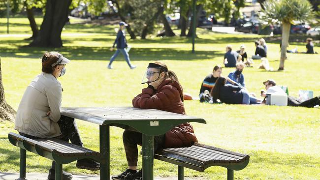 Two friends meet outside under Melbourne’s new restrictions.