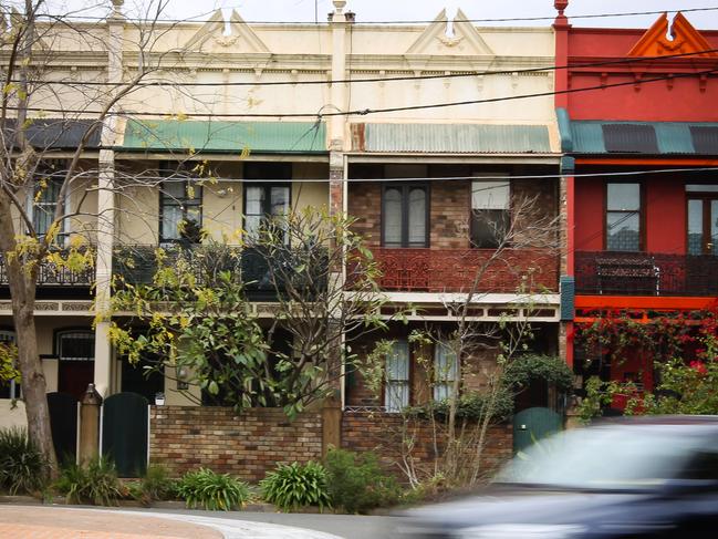 A car drives past a row of terrace houses in Sydney, Australia, on Tuesday, June 28, 2011. Australian home prices surged in the past two years, leaving the nation with the developed world's costliest homes, highest interest rates and among its most indebted households. Photographer: Ian Waldie/Bloomberg