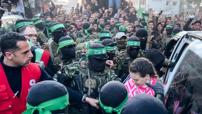 Doron Steinbrecher makes her way through a crowd of Hamas terrorists to a waiting Red Cross official during the latest hostage handover last Sunday. Picture: AFP