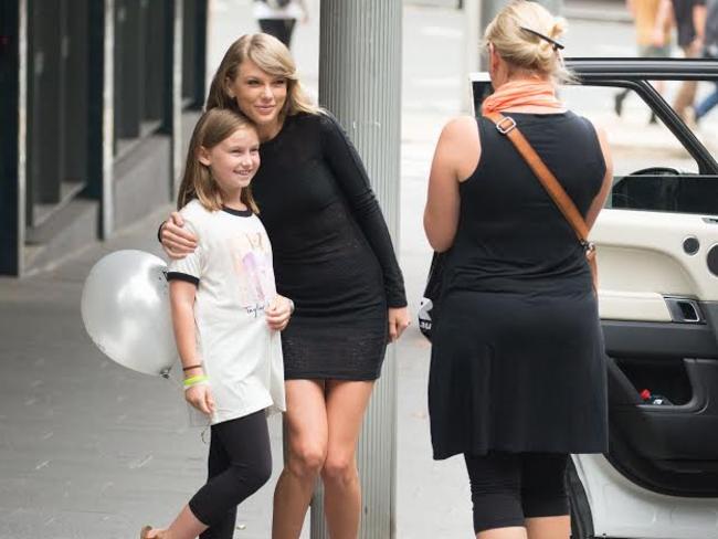 Taylor Swift poses for photos with a young fan on the streets of Sydney at the weekend. Pic: Media Mode/INF