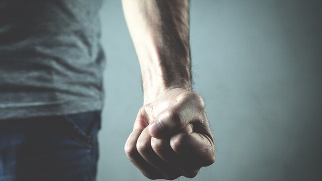 Caucasian angry and aggressive man threatening with fist.