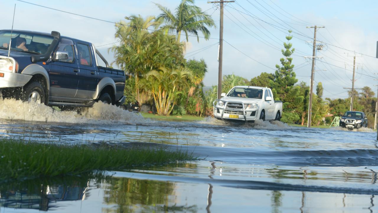 Cars drive through a flooded Fox Street in Ballina after an evacuation order was issued on Tuesday. Picture: Liana Boss