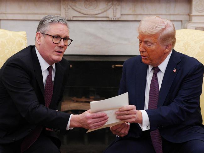 US President Donald Trump holds a letter from Britain's King Charles III during a meeting with British Prime Minister Keir Starmer in the Oval Office of the White House in Washington, DC, on February 27, 2025. Starmer is meeting Trump to plead for a US backstop to any Ukraine ceasefire, insisting it would be the only way to stop Russia's Vladimir Putin from invading again. Starmer arrived in Washington late Wednesday to build on a visit by French President Emmanuel Macron, amid growing concerns in Europe that the US leader is about to sell Kyiv short in negotiations with Putin. (Photo by Carl Court / AFP)