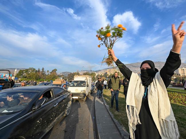 People celebrate at Umayyad Square in Damascus on December 8, 2024. Islamist-led rebels declared that they have taken Damascus in a lightning offensive on December 8, sending President Bashar al-Assad fleeing and ending five decades of Baath rule in Syria. (Photo by LOUAI BESHARA / AFP)