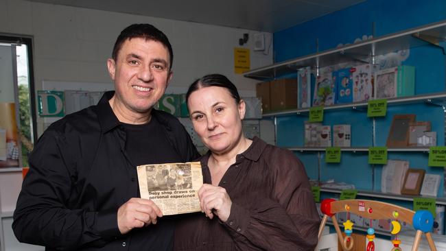 Nick and Trish Dellas the owners of store Baby2Kids at Rosny Park are closing down after 21 years. They are holding a story from The Mercury from when they first opened. Picture: Linda Higginson