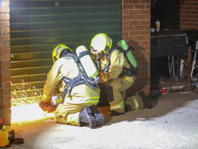 Firefighters work to free people trapped in a garage. Picture: Dean Asher