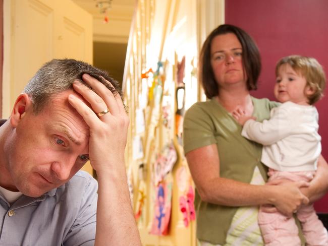 Man stresses over his bill while his wife and child stand in the background.