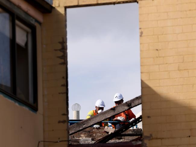 Workers remove bricks from a leaning back wall of E-Bike World in Croydon after a fire there in January. Picture: Damian Shaw