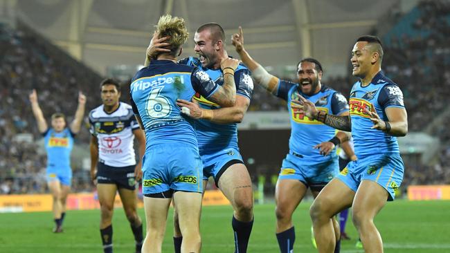 Kane Elgey of the Titans (centre) celebrates with Keegan Hipgrave (third right) and other teammates after scoring a try during the Round 25 NRL match between the Gold Coast Titans and the North Queensland Cowboys at Cbus Super Stadium. Photo: AAP