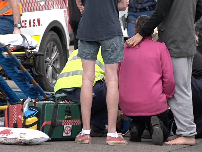 Paramedics work to stabilise the boy as bystanders watch on helplessly. Picture: David Cleverly