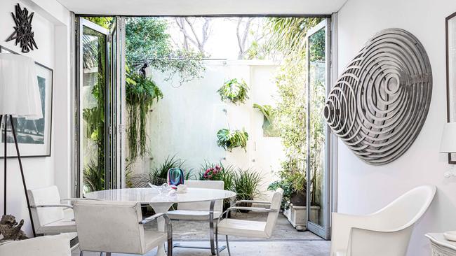 Living room and courtyard area. Simeon Nelson’s 'Planeon' wall sculpture made of plywood, plastic, metal, and laminates. Geoffrey Ricardo Zebra, Simeon Nelson star shape wall sculpture, Sarrinen round marble top table and chairs, Rosy Angelis floor lamp by Phillipe Starck. Picture: Flavio Brancaleone