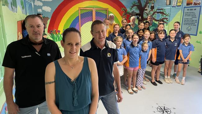 (L-R): Taubman's Danny Waddington, Girl Guides parent and mural artist Jessica Stoker and Royal Wolf manager Mark Williams inside the repaired Girl Guides clubhouse with members.