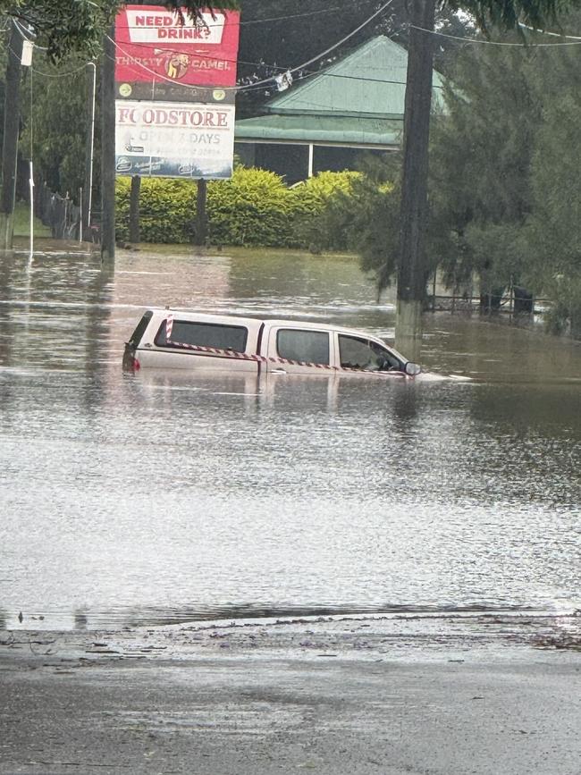 A car goes under floodwater from Cyclone Alfred at South Station Road in Booval, Ipswich. Picture: Molly Arlott/ Facebook