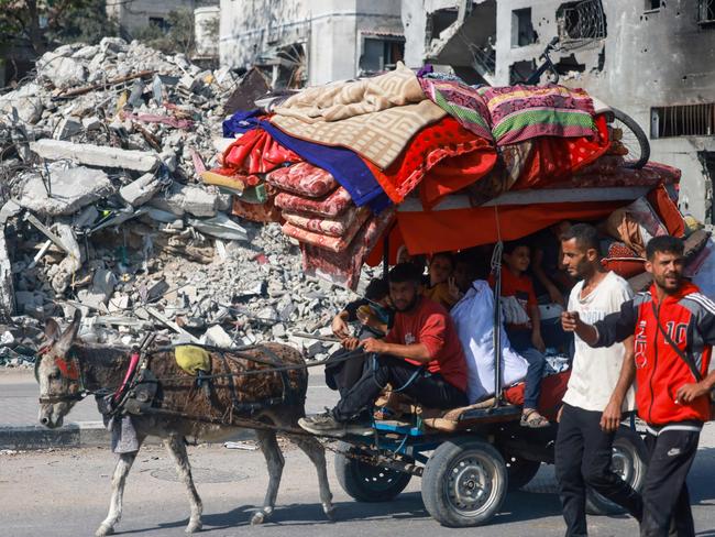 People ride a carriage with some of their belongings amid the rubble of destroyed buildings as they reach the central Gaza Strip via the Salah al-Din road on their way to the southern part of the Palestinian enclave. Picture: AFP