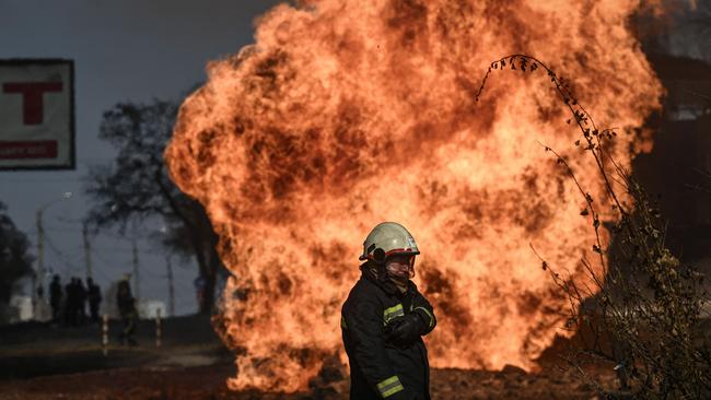 A Ukrainian firefighter stands next to flames rising from a fire following artillery fire on the 30th day on the invasion of the Ukraine by Russian forces in the northeastern city of Kharkiv. Picture: AFP