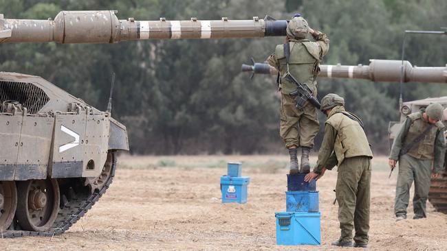 Israeli army soldiers check their Merkava tanks near the border with the Gaza Strip in southern Israel. Picture: Jack Guez/AFP