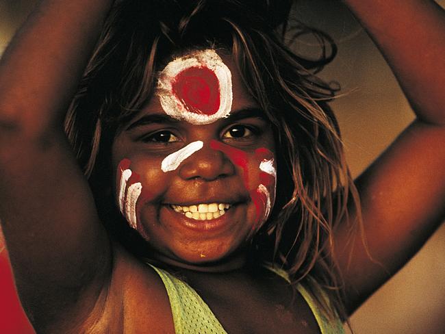 The people of the Tanami: The face of Carol Green Napangardi painted in the colours of her local footy team at Lajamanu on the Tanami Road. Picture: Bill Bachman