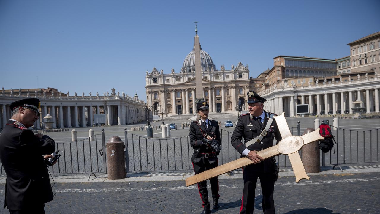 Italian Carabinieri carry a cross in St Peter's Square while Pope Francis celebrates the Easter Mass inside the empty St Peter's Basilica during the coronavirus emergency. Picture: Antonio Masiello/Getty Images