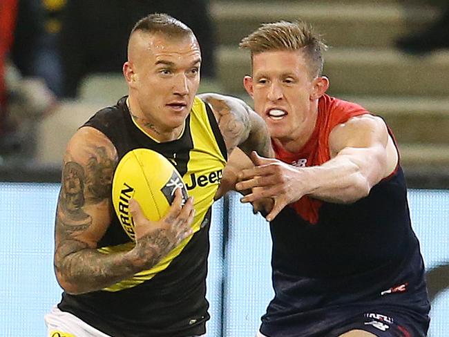 AFL Round 20. 03/08/2019.   Melbourne v Richmond at the MCG.  Richmonds Dustin Martin  brushes off the tackle of Melbourne's Sam Frost  1st quarter     .  Pic: Michael Klein