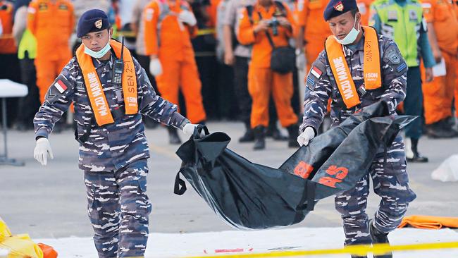 Indonesian navy personnel carry the remains of a victim of a Lion Air jet that crashed last October. Picture: AP/Tatan Syuflana