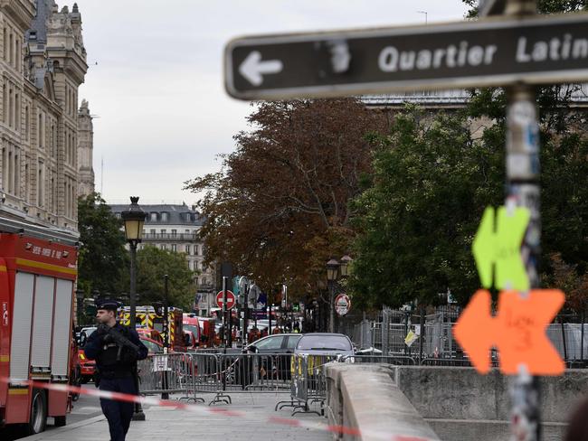 Police stand near a firefighter vehicle near Paris prefecture de police (police headquarters). Picture: AFP