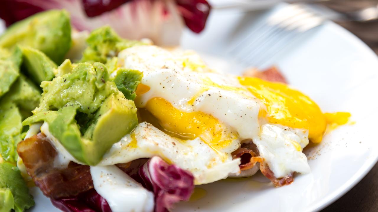 A typical keto breakfast includes eggs, avocado and smoked salmon with mushrooms and baby spinach.