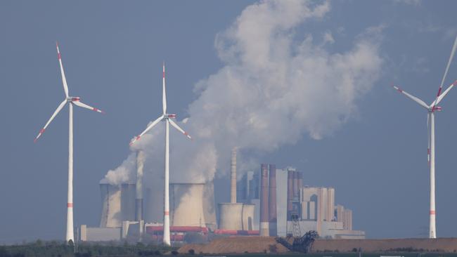 Wind turbines spin as steam rises from the Neurath coal-fired power station in Germany. Picture: Getty Images