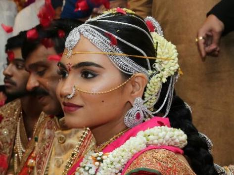 In this photograph received from the Janardhana Reddy family on November 16, 2016, daughter of Gali Janardhan Reddy, Bramhani (R) sits with her groom, Rajeev Reddy during their wedding at the Bangalore Palace Grounds in Bangalore. A controversial Indian mining tycoon has taken over a royal palace and flown in Brazilian dancers at a reported cost of 75 million dollars to celebrate his daughter's wedding, as the country reels from a cash crisis. / AFP PHOTO / JANARDHANA REDDY FAMILY / STR / RESTRICTED TO EDITORIAL USE - MANDATORY CREDIT 