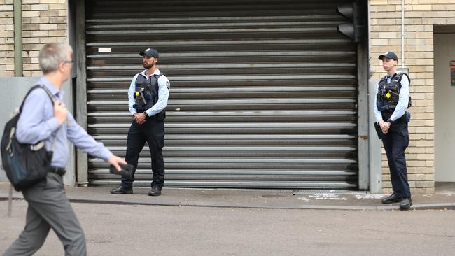 AFP officers guard the rear doors of the CFMEU in Pyrmont. Picture: John Grainger