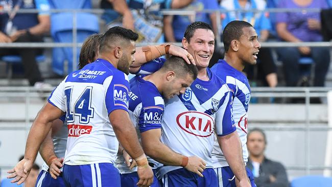 Bulldogs player Joshua Jackson (right) reacts with try scorerJack Cogger (centre) during the Round 10 NRL match between the Gold Coast Titans and the Canterbury Bulldogs at CBUS Super Stadium on the Gold Coast, Saturday, May 18, 2019. (AAP Image/Dave Hunt) NO ARCHIVING, EDITORIAL USE ONLY