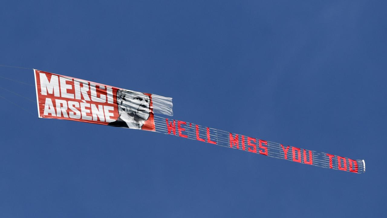 An airplane flies over the stadium with a message to Arsene Wenger