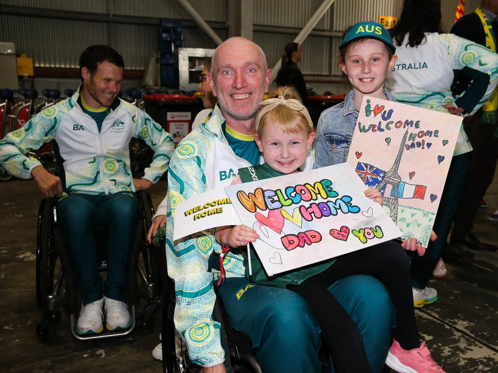 Two-time wheelchair rugby gold medallist, and now assistant national team coach and national development coach, Jason Lees, is welcomed home by his children Dakota and Ashlyn Lee. Picture: NewsWire / Gaye Gerard