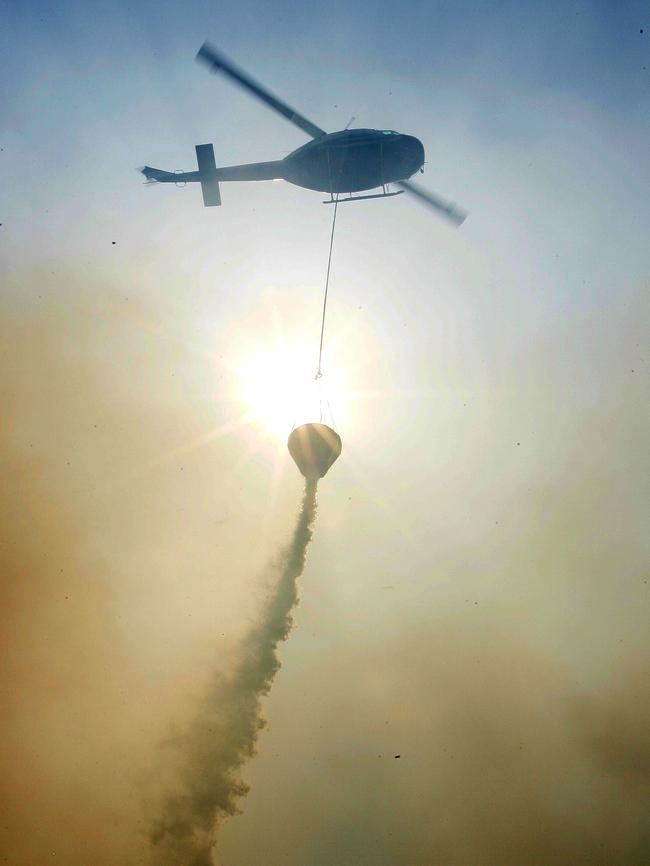 A chopper releases water that was threatening homes near Sydney.