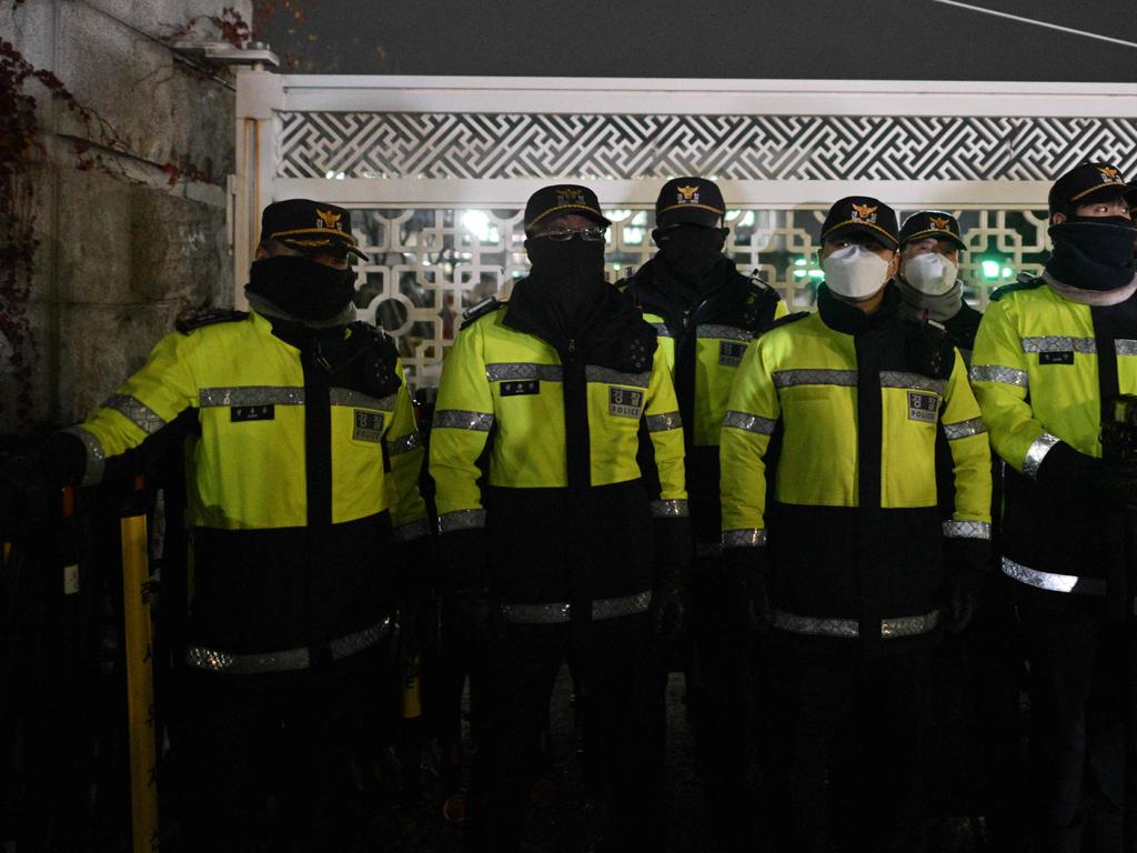 Police stand guard in front of the main gate of the National Assembly. (Photo by Anthony WALLACE / AFP)