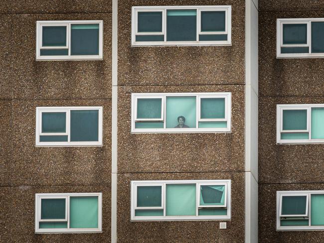 ***AUSTRALIA TOP STORIES - YEAR IN REVIEW*** MELBOURNE, AUSTRALIA - JULY 05: A lone woman is seen looking out the window of her apartment at the North Melbourne Public housing flats on July 05, 2020 in Melbourne, Australia. Nine public housing estates have been placed into mandatory lockdown and two additional suburbs are under stay-at-home orders as authorities work to stop further COVID-19 outbreaks in Melbourne. The public housing towers will be in total lockdown for at least five days following a high number of positive coronavirus cases recorded in residents on those estates. The towers will be closed and contained, and the only people allowed in and out will be those providing essential services. Police will be placed on each floor of the towers and other police will control access points to the estates. Residents of 12 Melbourne hotspot postcodes are also on stay-at-home orders and are only able to leave home for exercise or work, to buy essential items including food or to access childcare and healthcare. Businesses and facilities in these lockdown areas are also restricted and cafes and restaurants can only open for takeaway and delivery.  (Photo by Asanka Ratnayake/Getty Images)