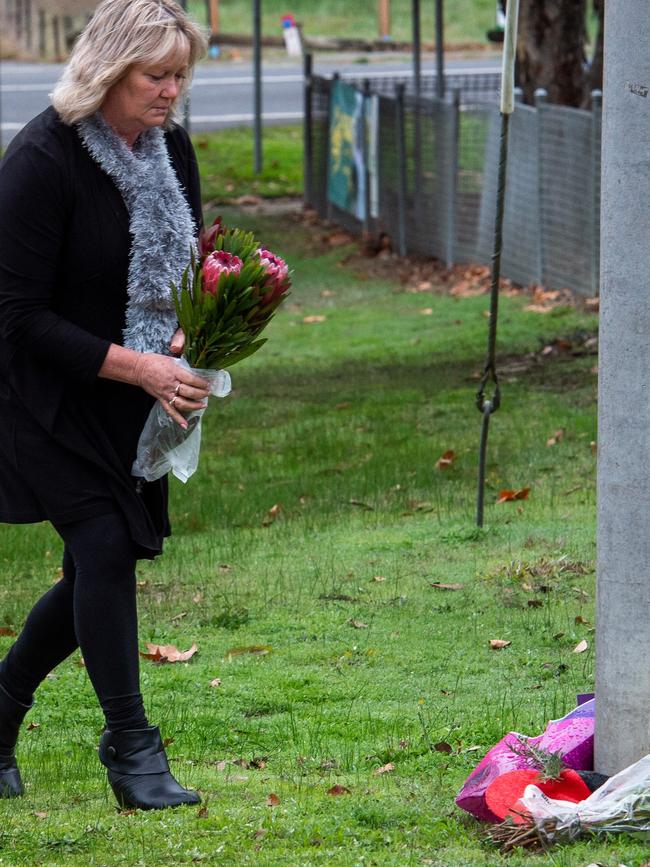 A woman carries flowers to the scene. Picture: Jay Town