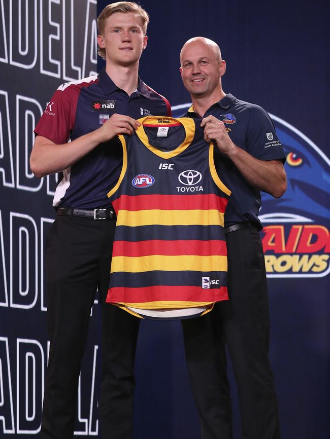 New Adelaide coach Matthew Nicks hands the Crows guernsey to their top draft pick Fischer McAsey. Picture: Getty Images