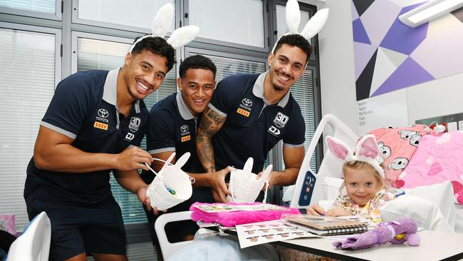 Harper Shea, 5, receives Easter treats from Cowboys players Murray Taulagi, Viliami Vailea and Robert Derby at the Children's Ward, Townsville University Hospital. Picture: Shae Beplate.