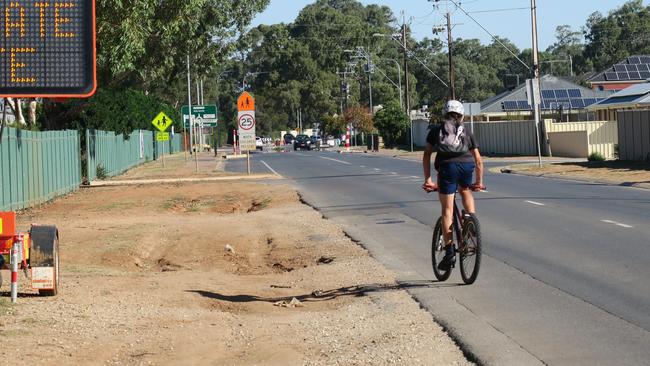 A young cyclist riding on Heaslip Road beside underdeveloped land in front of Trinity College. Picture: Jason Katsaras