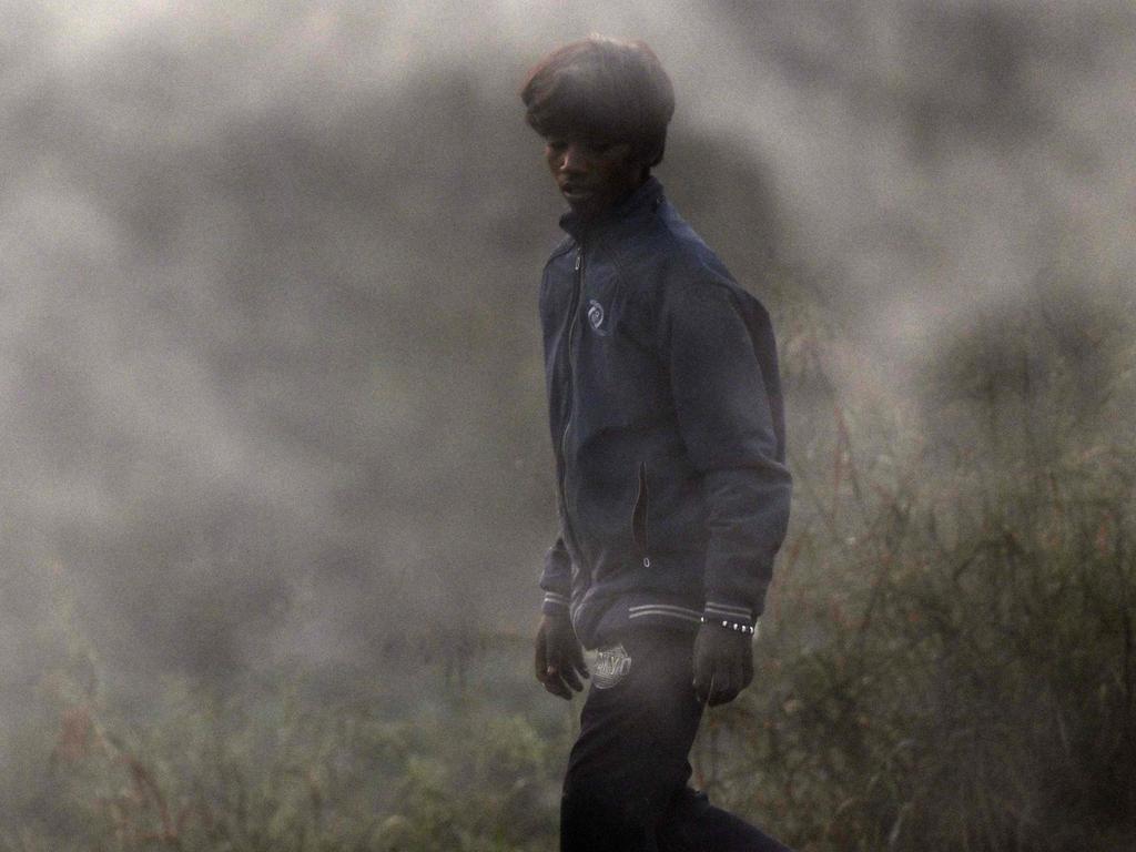 Smoke billows from burning garbage as a young boy looks for reusable waste amid smoggy conditions at the Ghazipur landfill in New Delhi on November 19, 2024. Picture: Arun Sankar/AFP