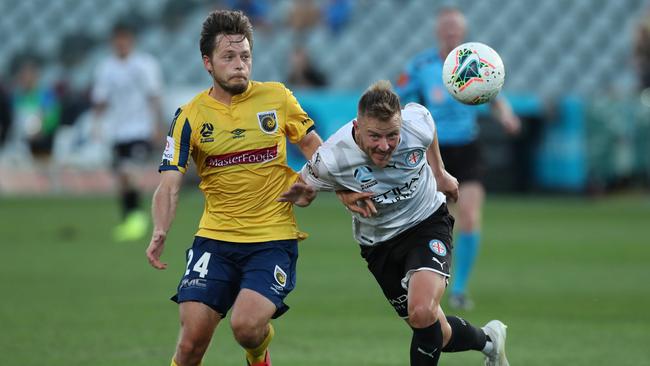 Scott Jamieson of Melbourne City and Chris Harold of the Central Coast Mariners contest the ball before the A-league was stopped.