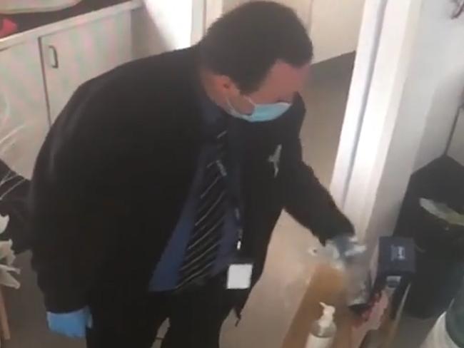 Victoria Police detective caught on camera pocketing toothpaste from a dentist during raid. Source: CCTV Supplied.
